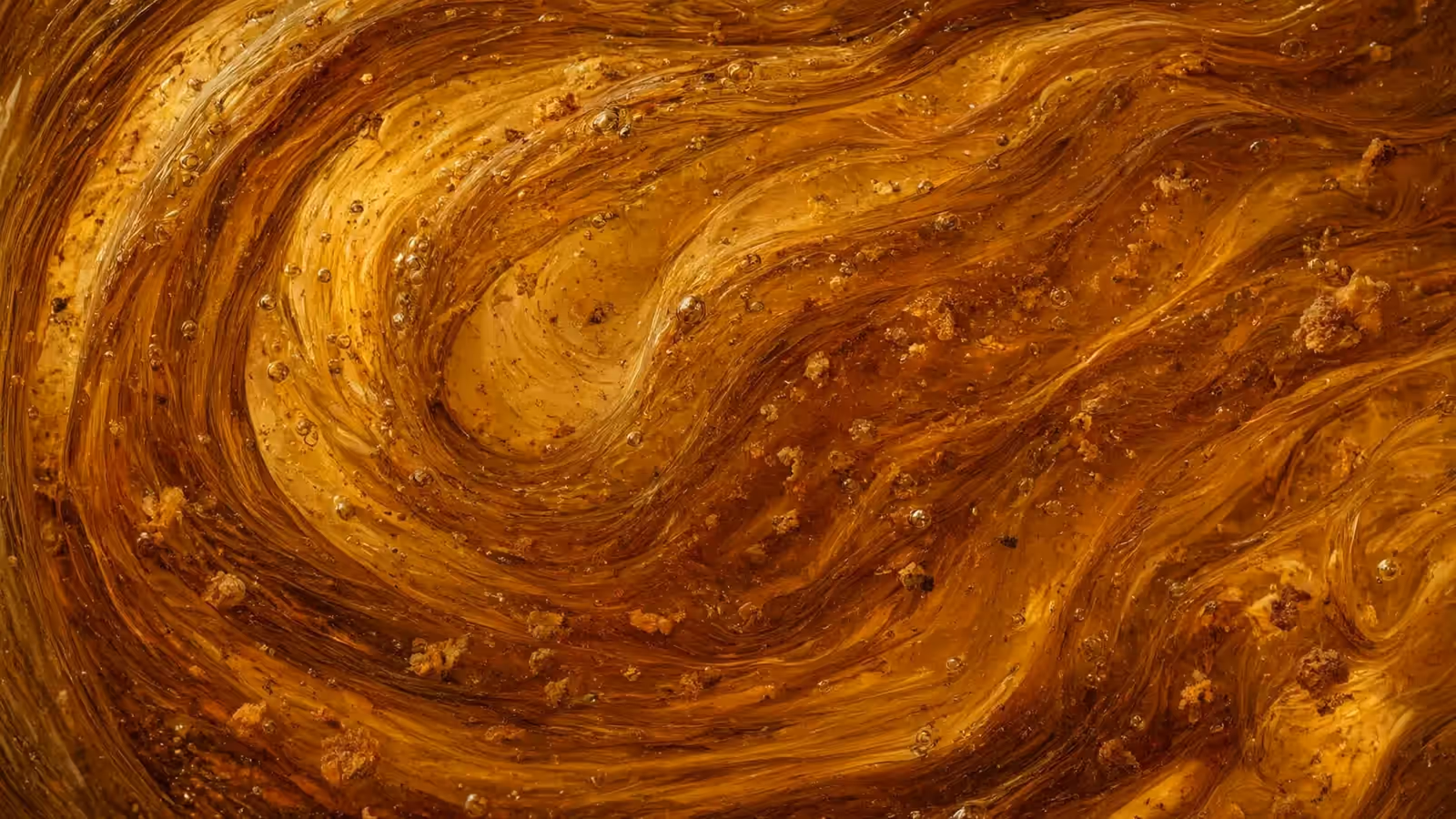 Amber perfume concentrate swirling as it rests